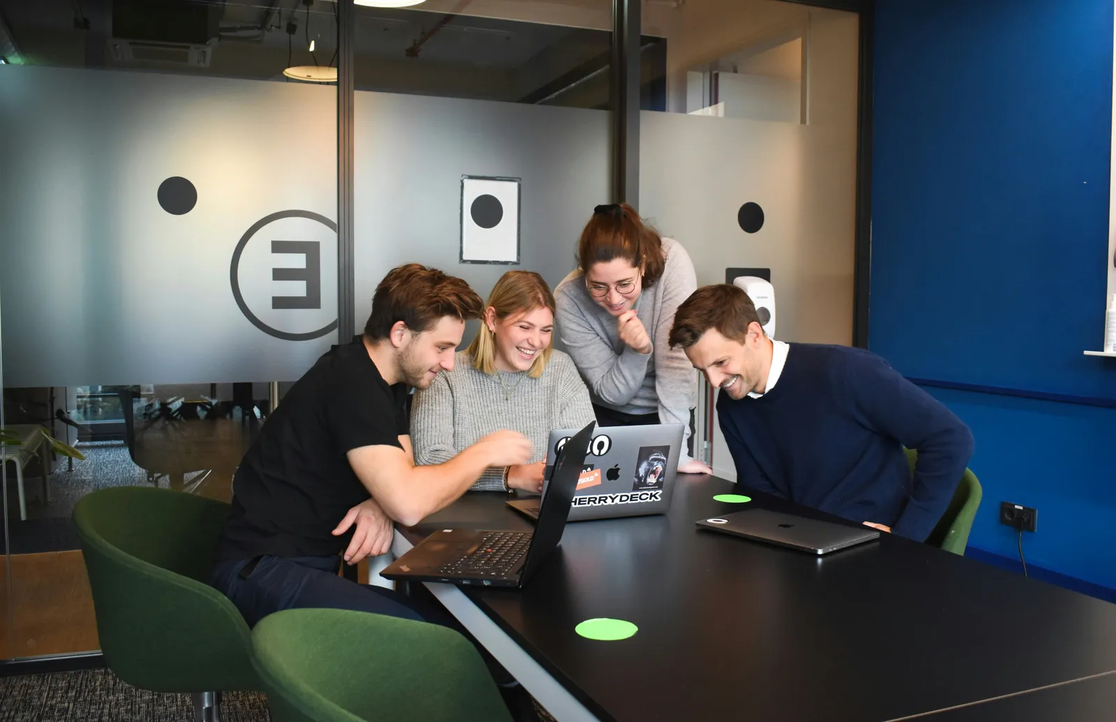 Équipe au travail en salle de réunion, postes portables connectés au réseau Wi-Fi